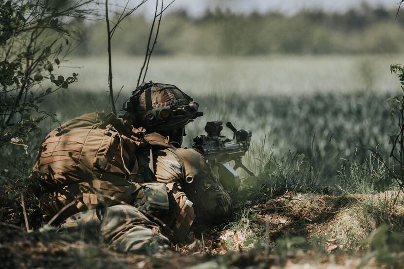 Militair met geweer in het veld.