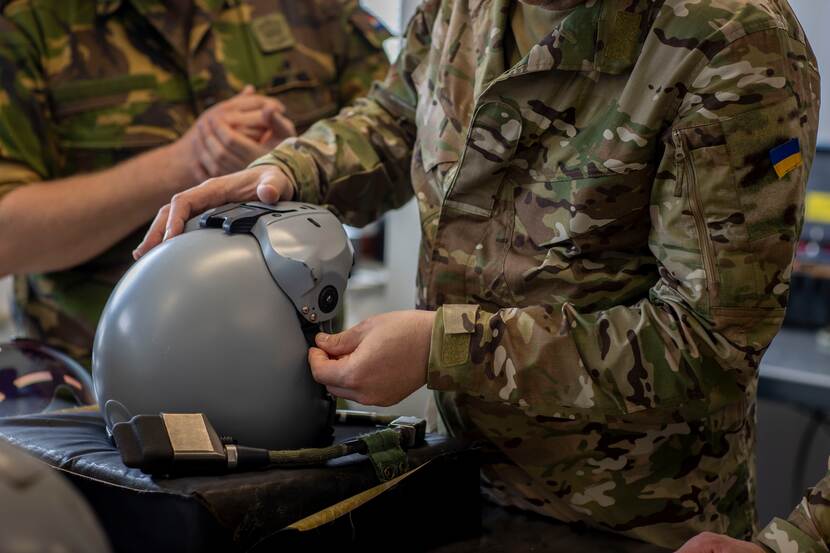 Militair inspecteert vliegerhelm.