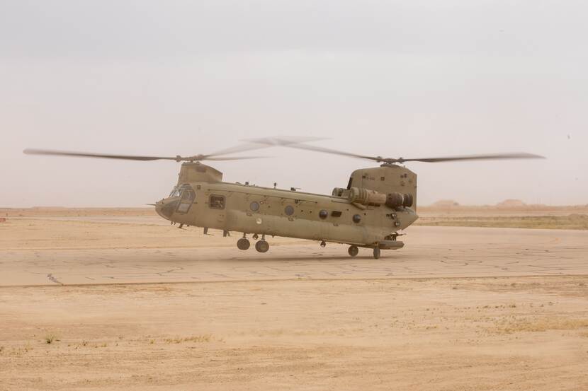 Chinook stijgt op. Woestijnachtige grond.