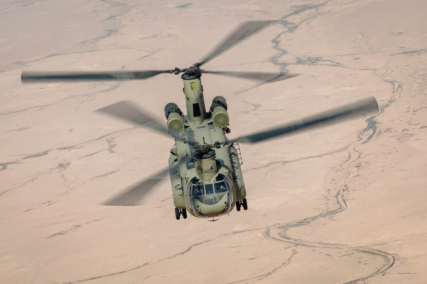 Vliegende Chinook van bovenaf gefotografeerd boven het Irakese zandlandschap.