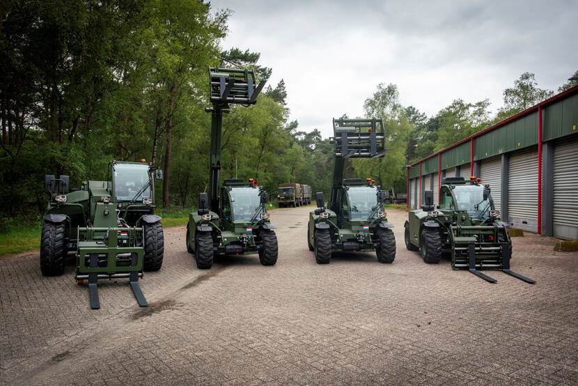 Vier verreikers staan op een rij voor een garagebox