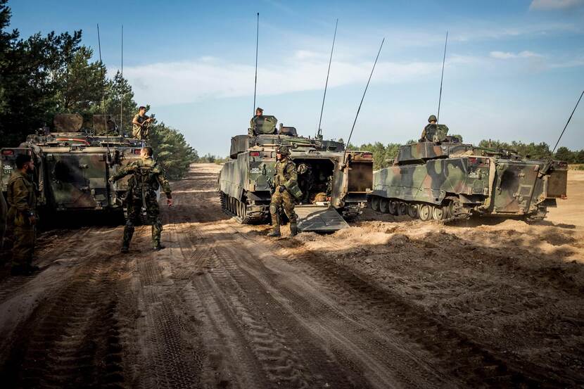 Militairen oefenen met CV90-pantserinfanterievoertuigen.