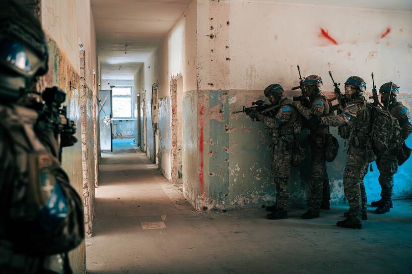 5 Militairen oefenen in een oud gebouw.