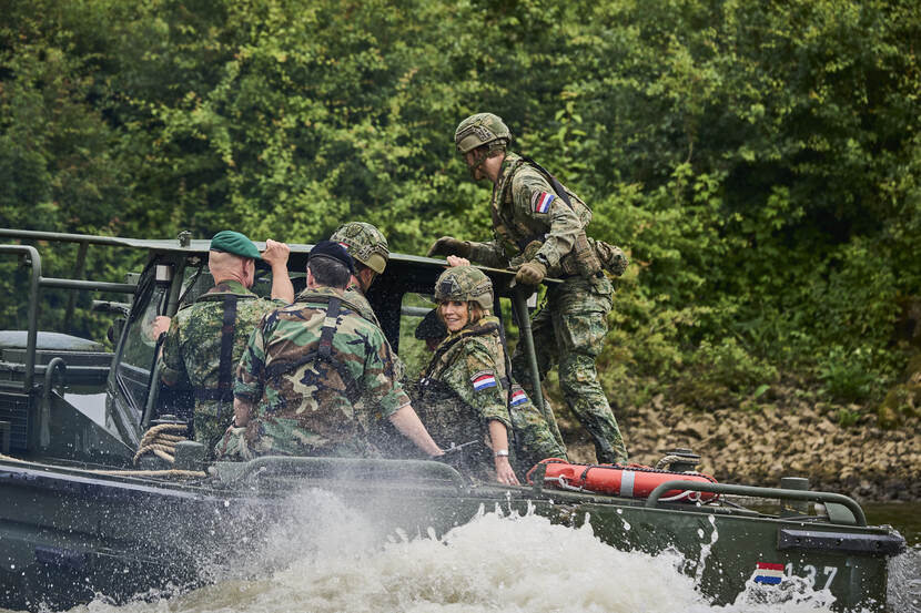 De koningin zit in een militair vaartuig.
