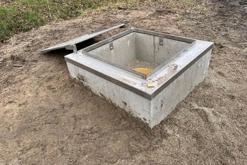 Waterput in vierkante betonnen omheining.