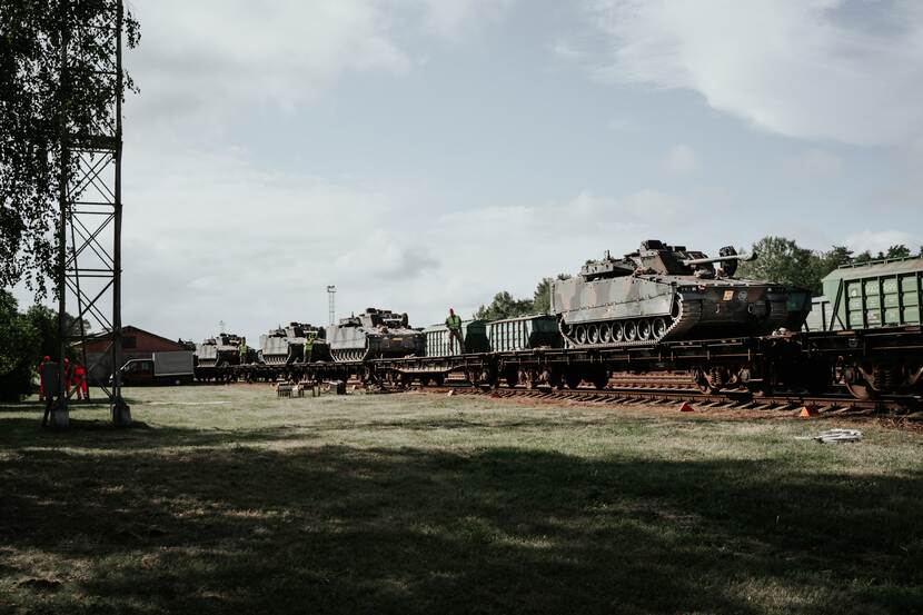 Militaire voertuigen staan op de rails.
