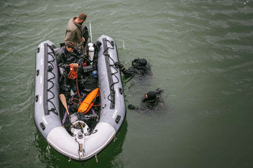 Duikers van de marine zoeken naar mijnen bij een oefening