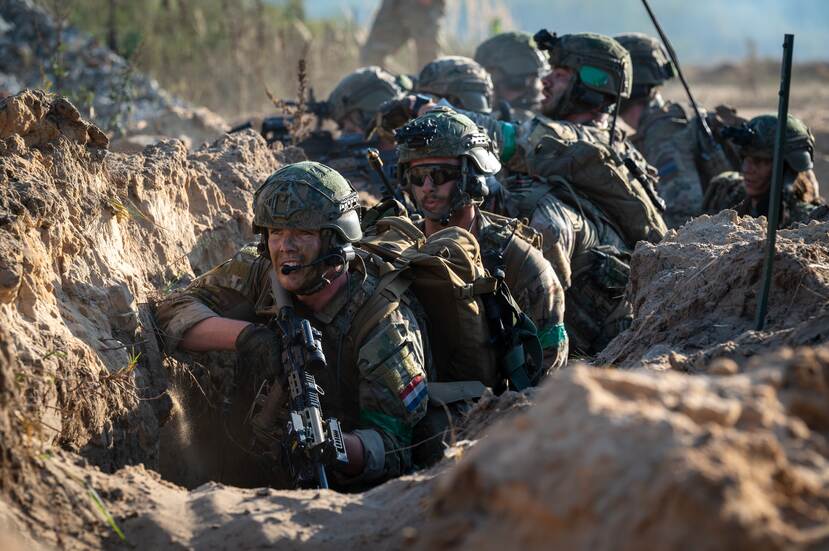 Rij militairen in loopgraf.