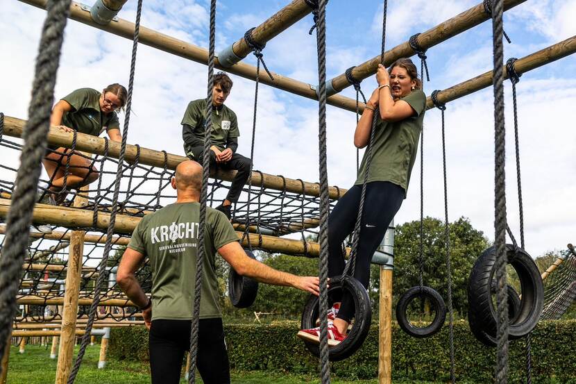 Jongeren klimmen en hangen in de touwen.