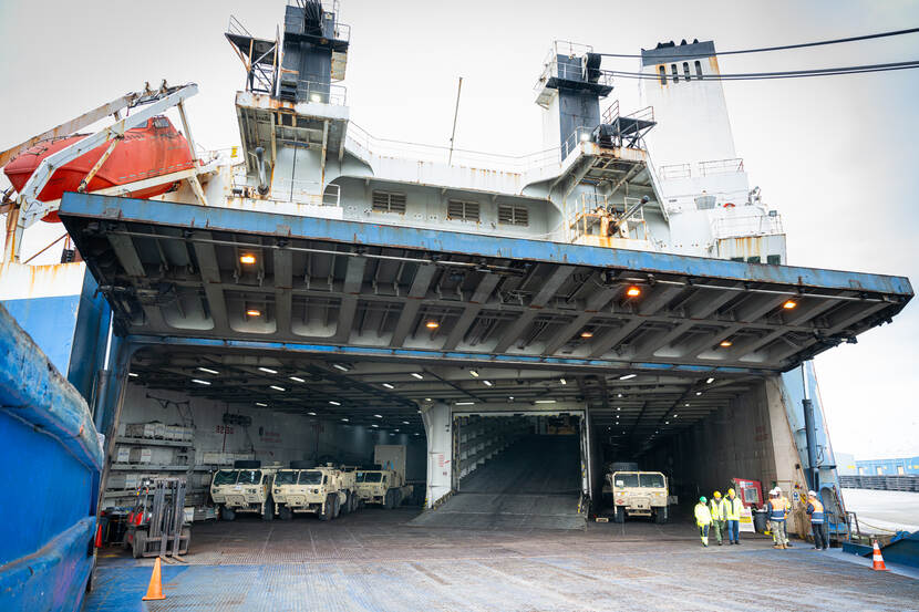 Een schip vol materieel wordt uitgeladen.