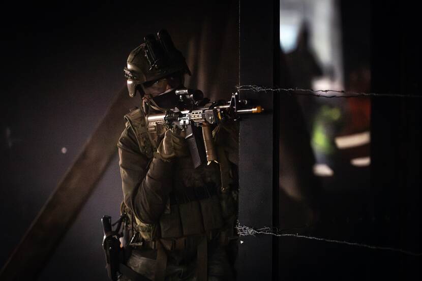 Een militair richt zijn wapen.