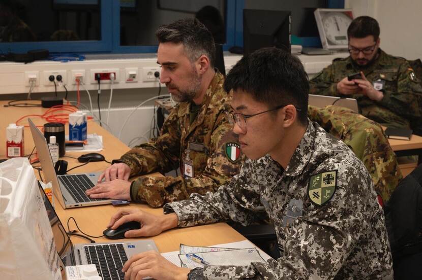 militairen achter beeldschermen.