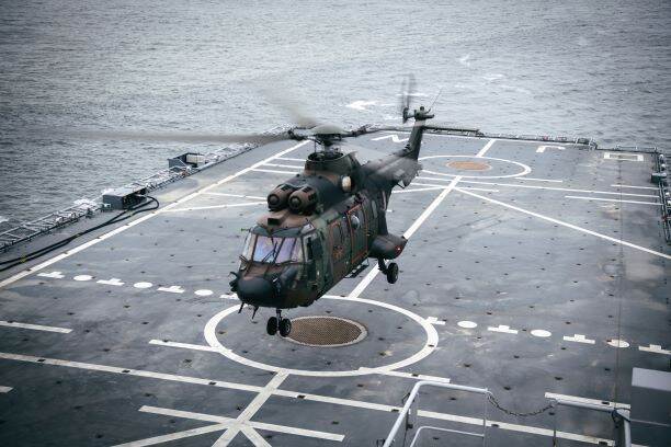 Een Cougar-transporthelikopter boven het marineschip Zr. Ms. Johan de Witt.