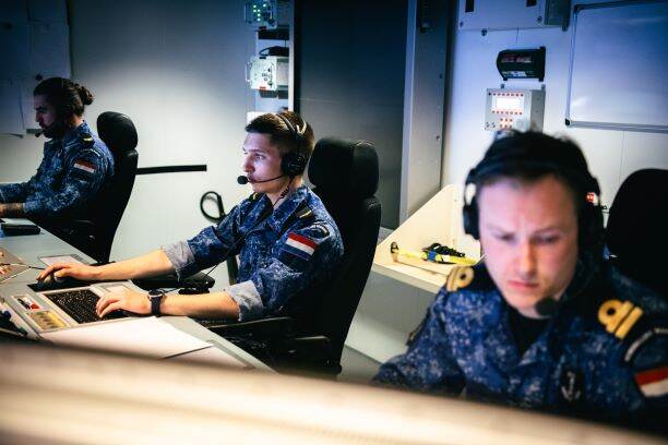 Militairen kijken op hun computerschermen.
