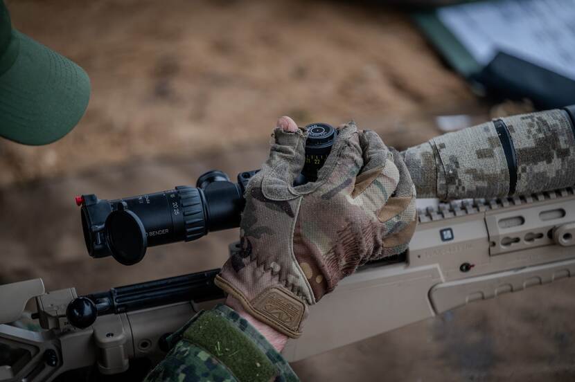 Hand van militair op wapen.