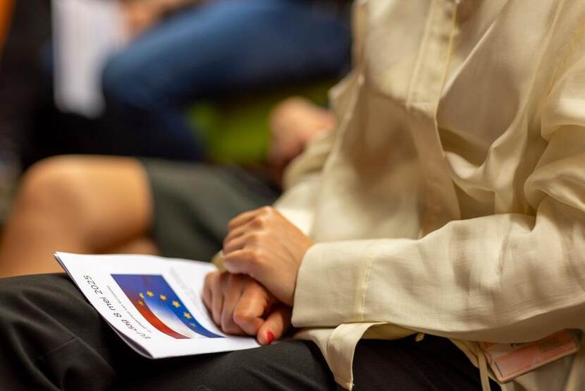 Schoot van een persoon met folder op schoot met logo Europa.