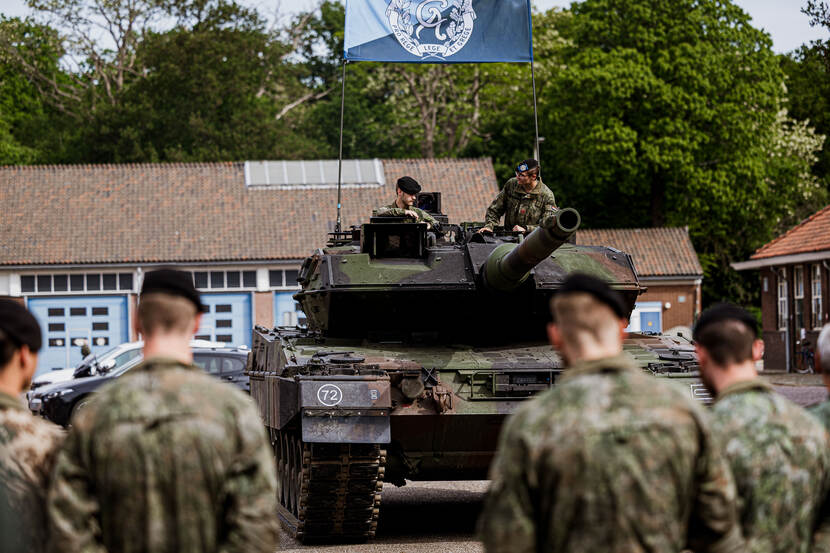 Militairen zitten op een tank.