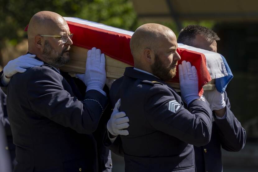 Luchtmachtmilitairen dragen stoffelijke resten op de schouder,