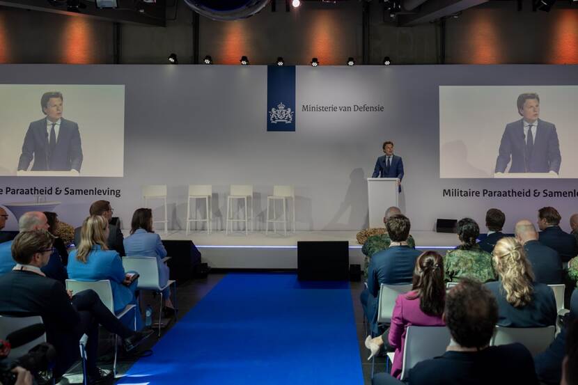Minister Ruben Brekelmans staat op een podium voor een zaal met mensen.