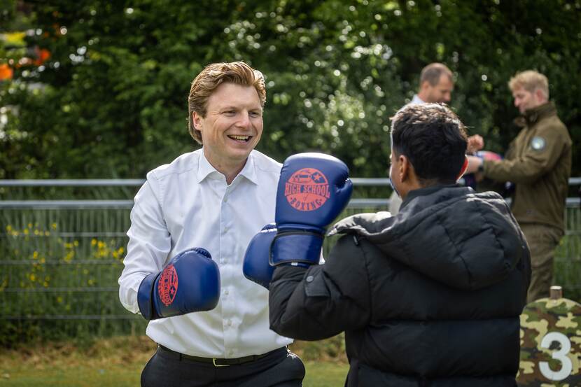Minister Brekelmans bokst met een jongere.