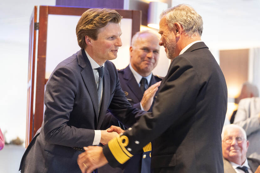 Minister schudt Bauer de hand. CDS staat er ook bij.