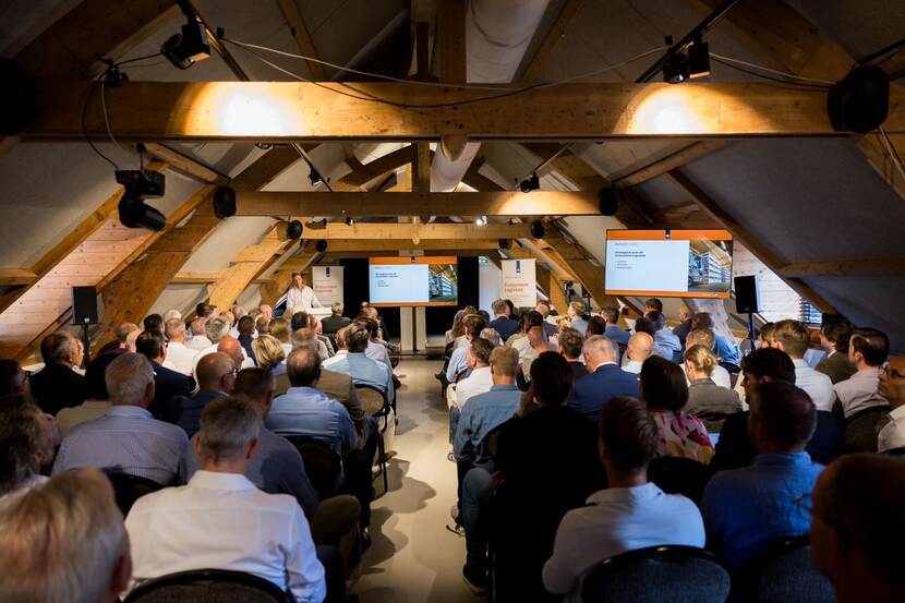 Een informatiebijeenkomst in Kasteel Woerden voor de diensten wegtransport en overslag met achterhoofden van de deelnemers en  luitenant-generaal Jan-Willem Maas op het podium.