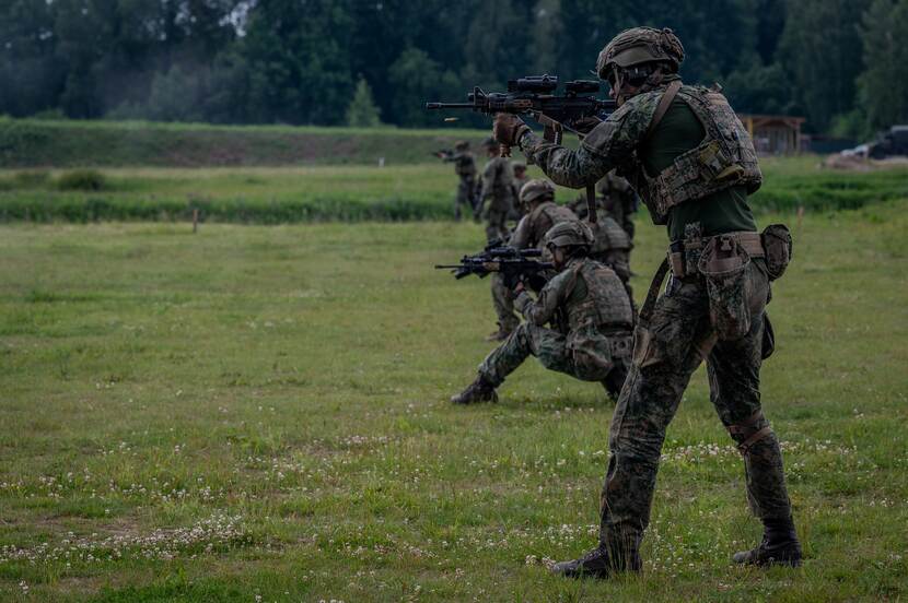 Militairen in rij aan het schieten.