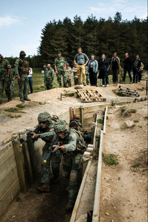 Brekelmans kijkt naar militairen die trainen in loopgraven.