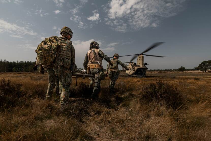 Militairen dragen een gewonde naar Chinook.