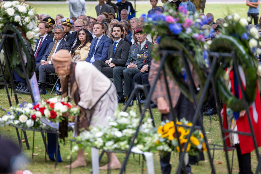 Vrouw legt een bloemenkrans.
