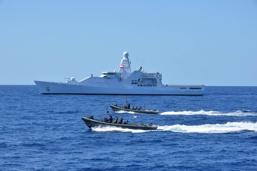 Zr.Ms. Friesland vaart op zee, met 2 Frisc motorboten op de voorgrond.