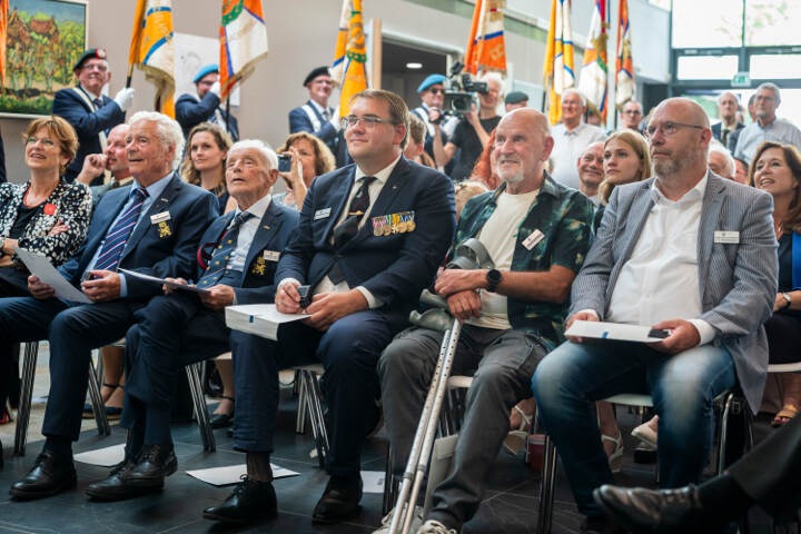 Oorlogs en dienstslachtoffers en hun relaties zitten op stoelen tijdens de uitreiking.