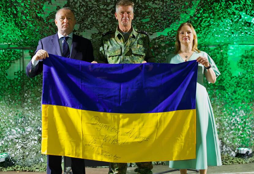 De Oekraïense inspecteur Olha Reshetylova houdt de Oekraïense blauwgeld vlag omhoog waarop met pen ‘Dignity always wins’ geschreven staat.