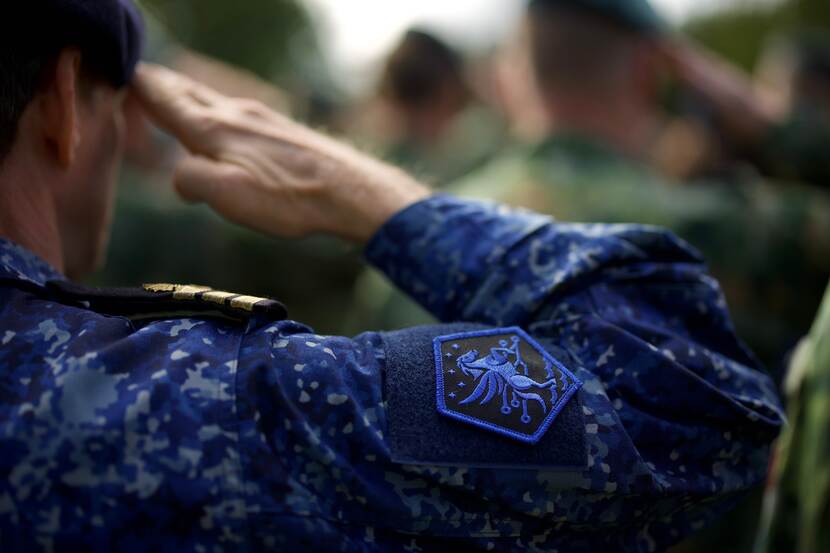 Een militair met het embleem van JFC op het uniform brengt een groet uit.