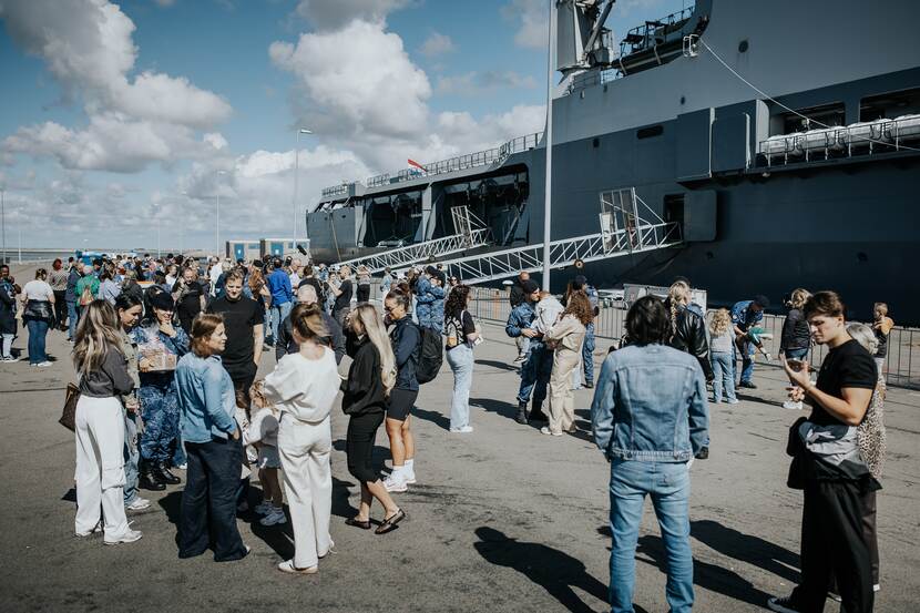 Familieleden van marinepersoneel op de kade.