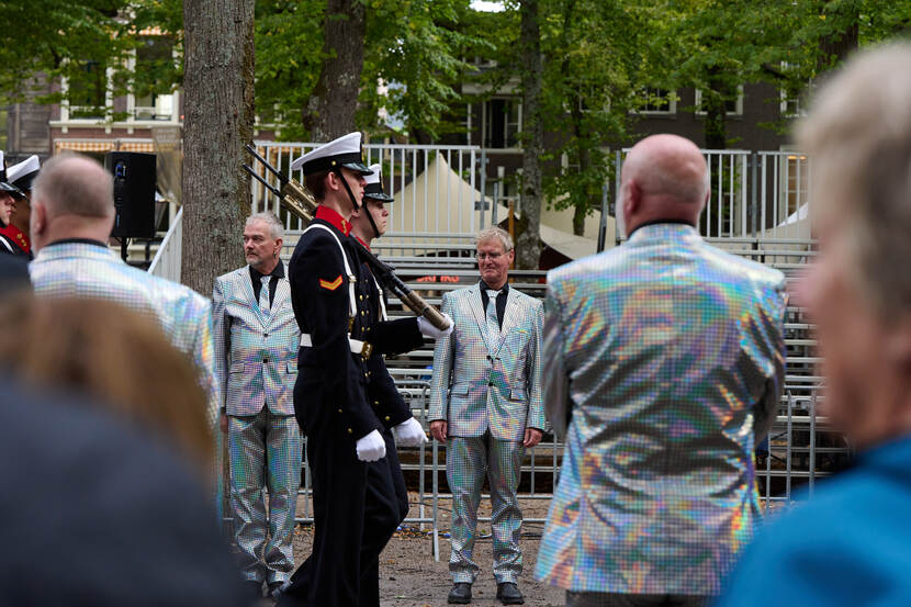 Publiek met glanzend zilveren pakken.