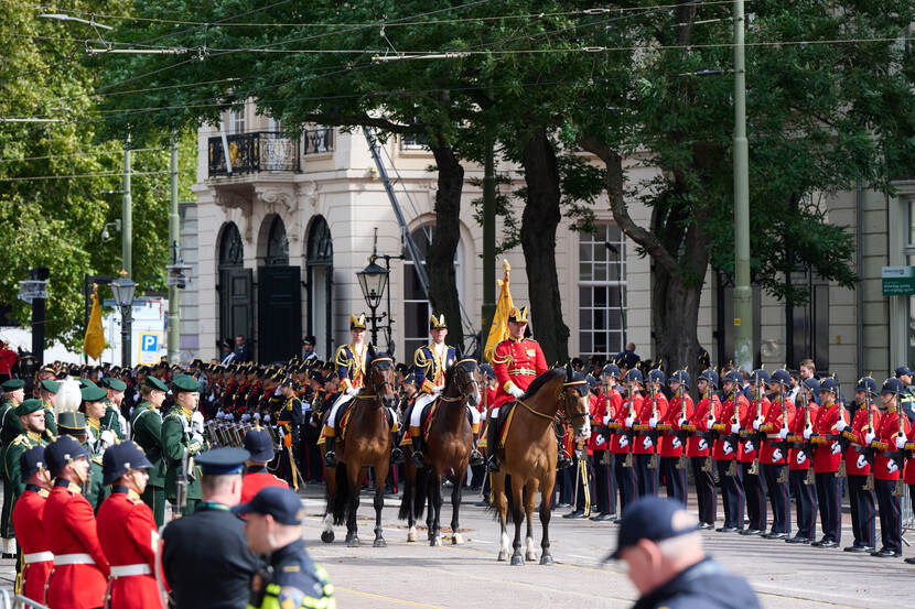 3 paarden\, geflankeerd door militairen.