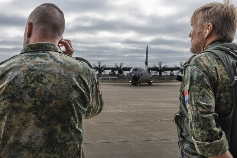 Hercules op de grond met links een militair op de rug en rechts de koning, eveneens in uniform.