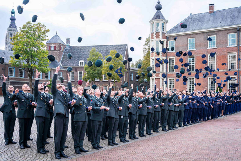 Officiers gooien hun pet in de lucht.