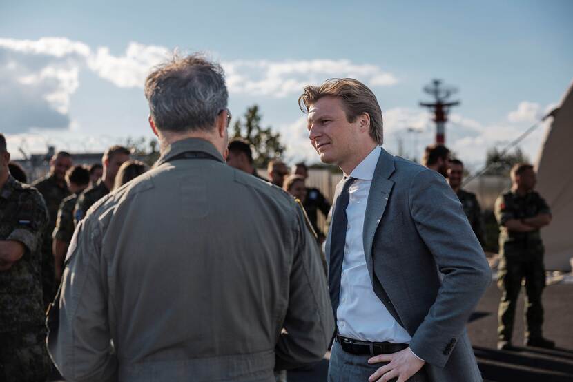 Minister Brekelmans in gesprek met militair. Op de achtergrond meer militairen.