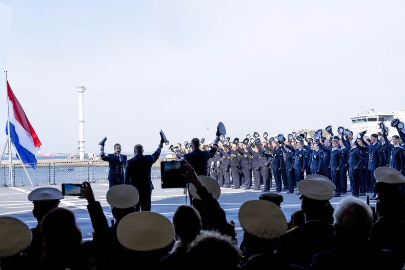 Mariniers gooien hun baret in de lucht.
