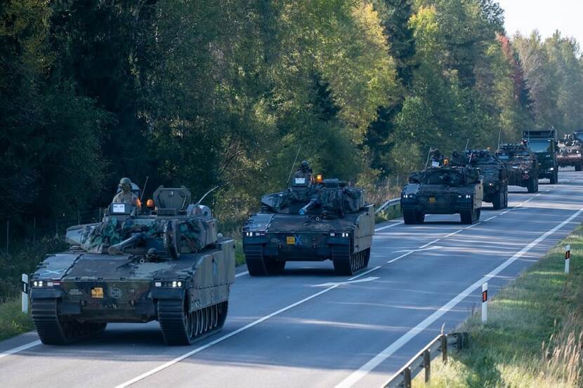 Militaire voertuigen in kolonne op een Litouwse weg