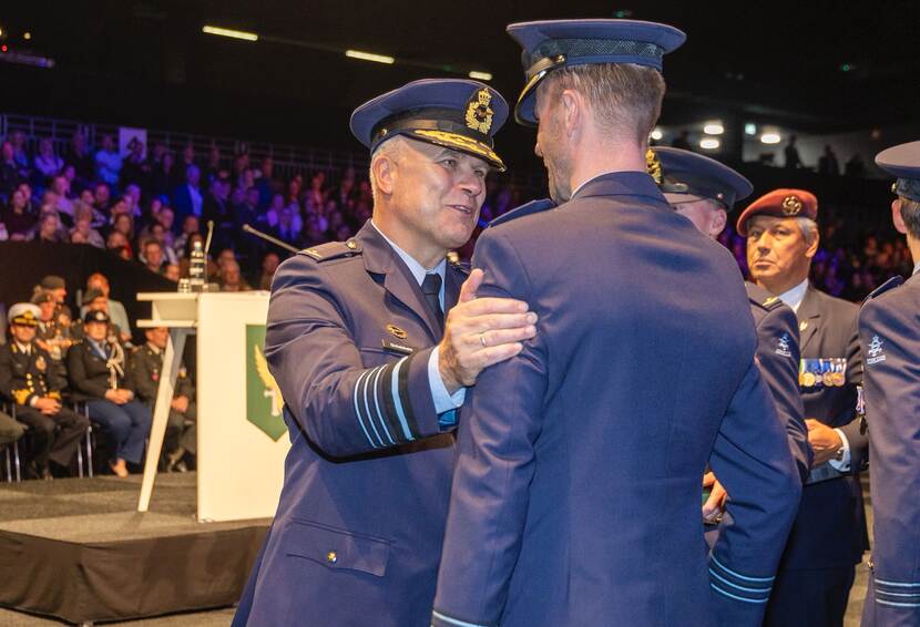 De CDS heeft zijn hand op de schouder van een militair.