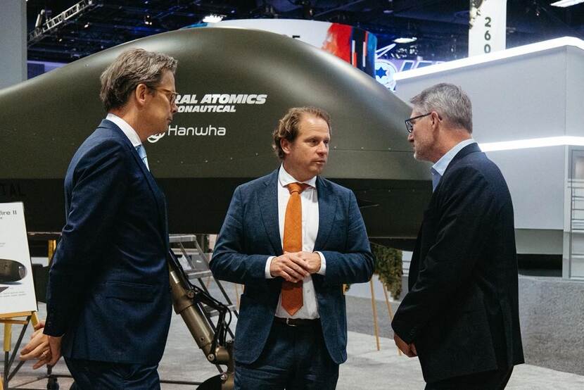 Staatssecretaris Tuinman in gesprek met 2 mannen.