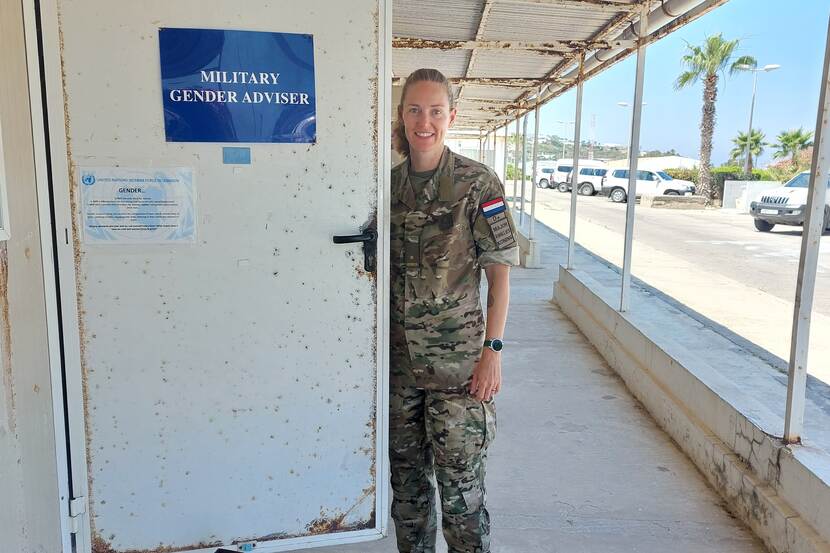 Vrouwelijke militair staat bij deur van haar kantoor. Op de deur staat te lezen: Military Gender Adviser.