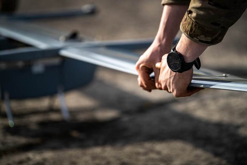 Militair heeft drone in zijn hand.
