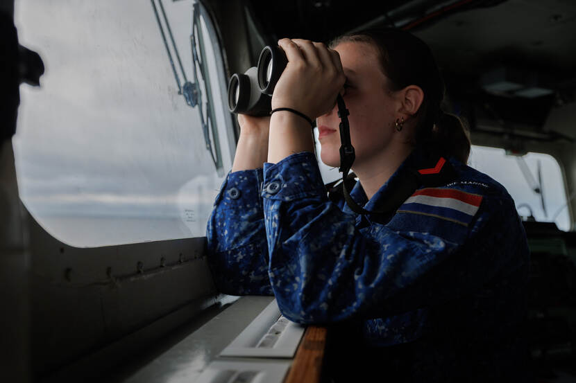 Matroos kijkt uit naar een (vijandelijke) onderzeeboot.