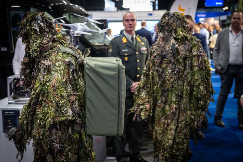 De staatssecretaris in gesprek met 3 jonge militairen op de beursvloer.