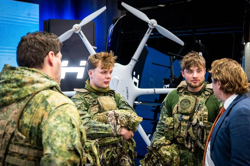 Tuinman in gesprek met 3 jonge militairen.