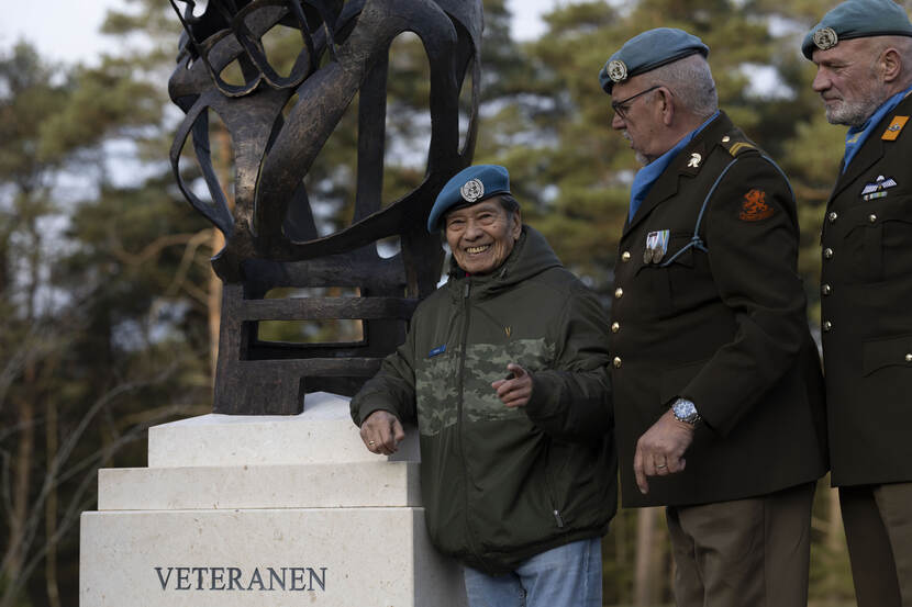3 veteranen staan aan de voet van het monument.